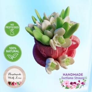 Handmade soap sculpture of a bouquet of white snowdrop flowers in a pink knitted mug. The soap is labelled "100% Natural" and "No Pesticides". The soap is also labelled "Handmade with Love" and "Handmade Svetlana Strauss".
