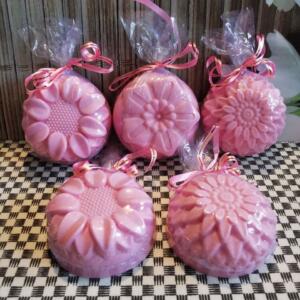 Six pink soap bars with a flower design, wrapped in clear plastic and tied with pink ribbon.