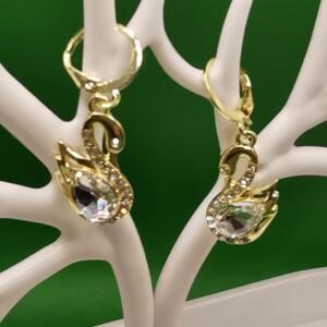 A pair of gold swan earrings with clear crystal accents. The earrings have a hook fastening.
