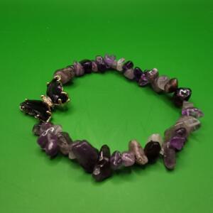 A purple and grey gemstone bracelet with a gold butterfly charm. The bracelet is made of small, irregular shaped stones.