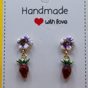 A pair of dangle earrings featuring a white flower and a red strawberry charm. The earrings are displayed on a white card with the text "Handmade with love".