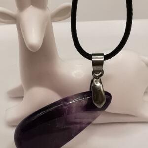 A pendant necklace with a polished, teardrop-shaped amethyst gemstone. The purple stone hangs from a black cord with a silver-coloured metal clasp. The necklace is displayed against a white background.